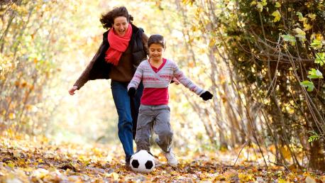 An image of a mom and son playing soccer. 